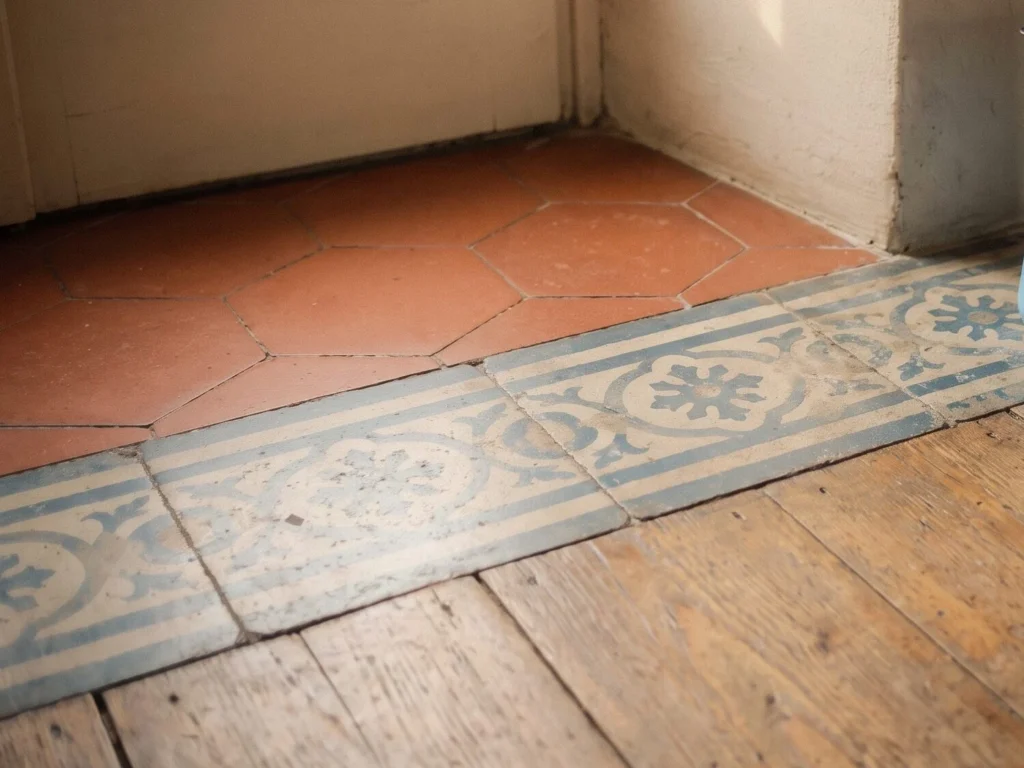 Pavimento in cotto con una fascia di cementine decorate in una cucina ristrutturata